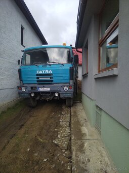 Tatra 815 prechádzajúca úzkym prístupom medzi domami
